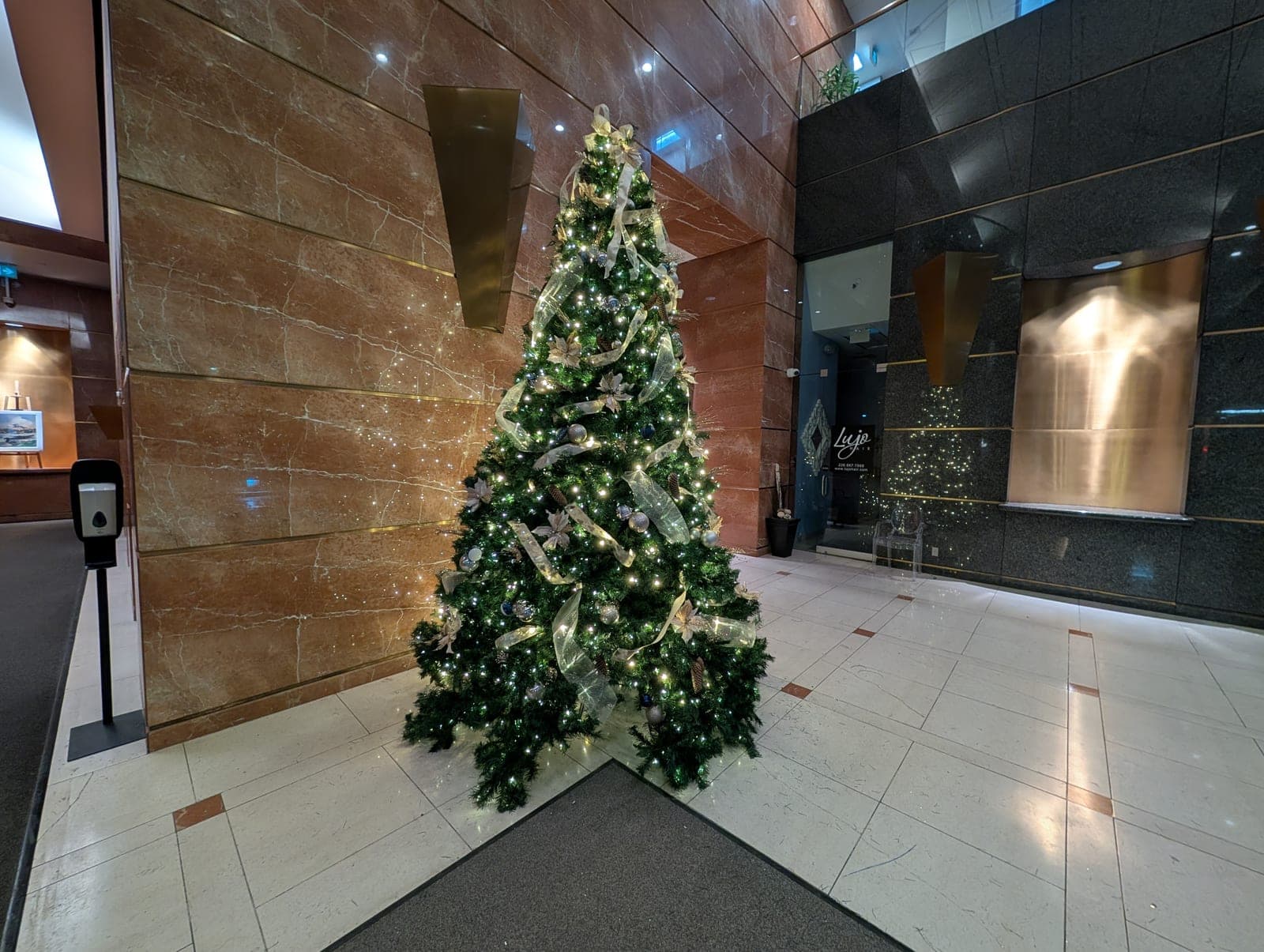 Elegant decorated Christmas tree in a corporate marble atrium lobby at a commercial building