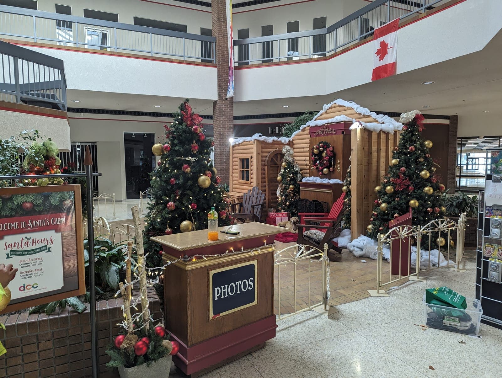 Welcome to Santa's Cabin holiday display in a mall atrium with fully decorated Christmas trees